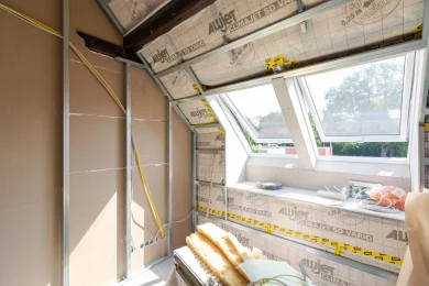 Eingebautes Dachflächenfenster, daneben die verklebte Dampfbremse und Mineralwolle