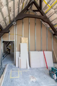 Neues Metallständerwerk und Trockenbauplatten unter dem alten Holzdachstuhl