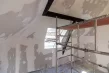 Verspachtelte Gipskartonflächen im Dachgeschoss, davor ein Rollgerüst